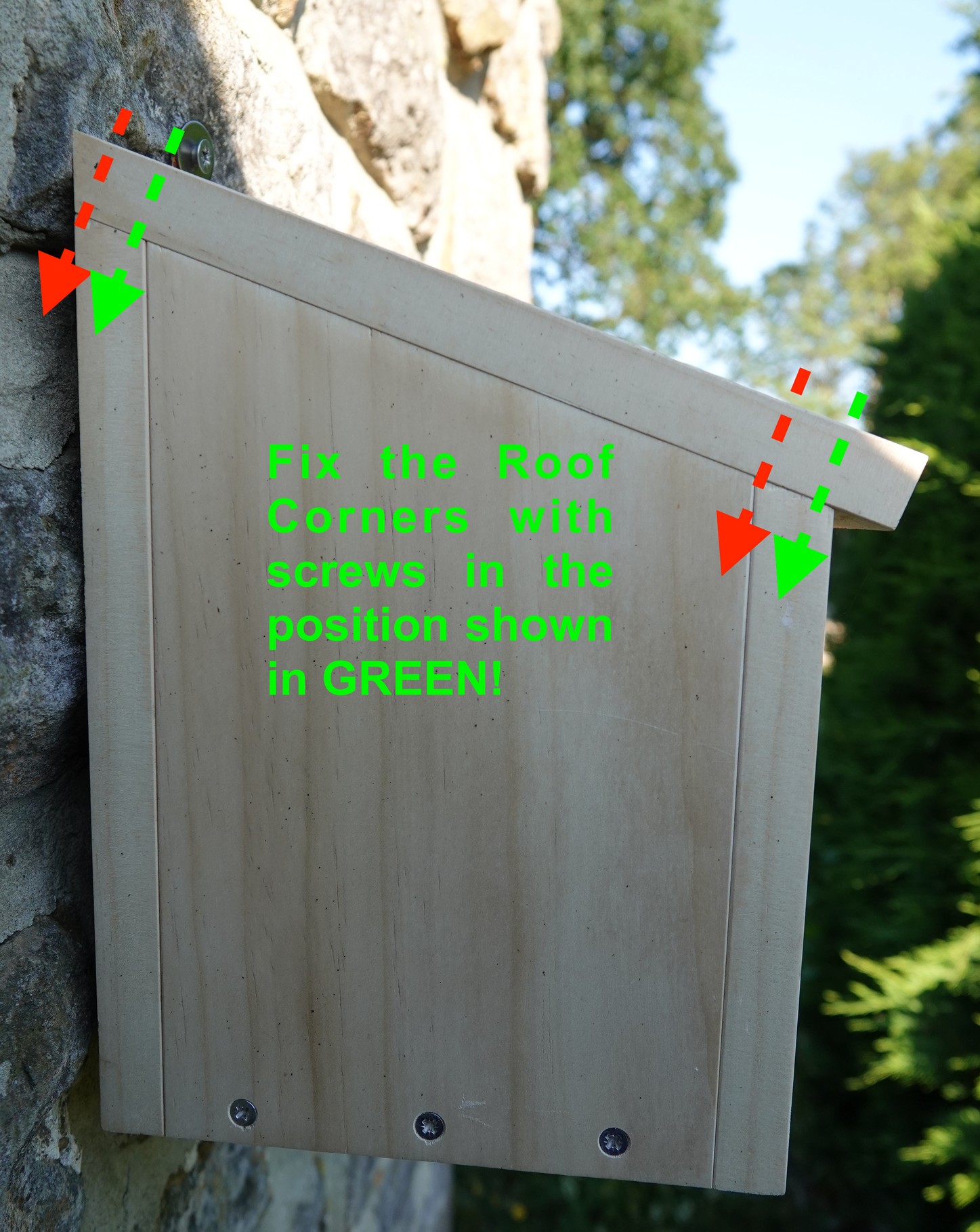 Mounted nest box with red and green arrows showing the correct positions for the roof screws
